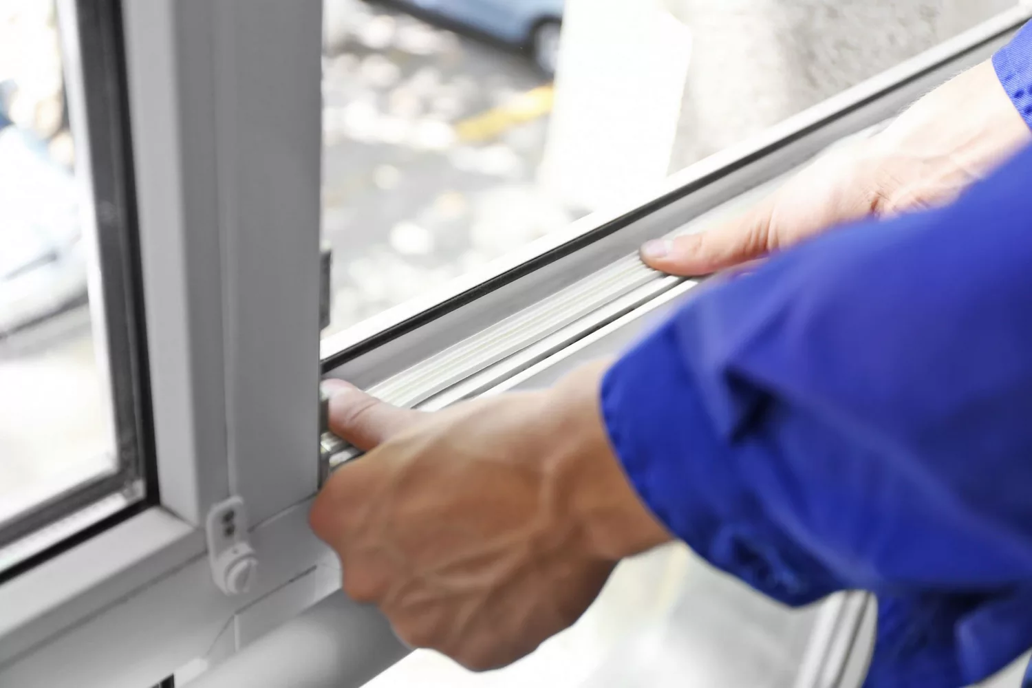 Close-up of glazier fitting a seal on a window frame